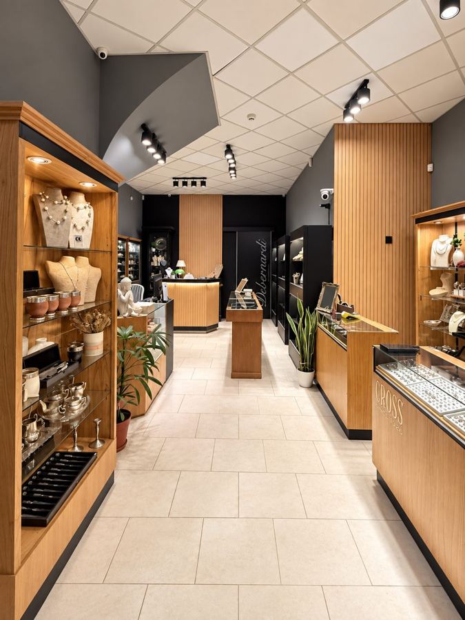 Pasillo del local con vitrinas de madera, joyas y platería